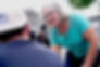 Sheryl leaning down to chat with a South Dakota resident wearing a ball cap